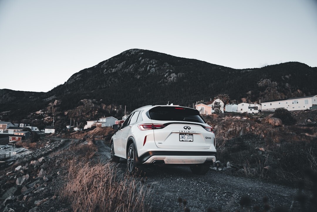 Luxury car driving on a coastal road at sunset